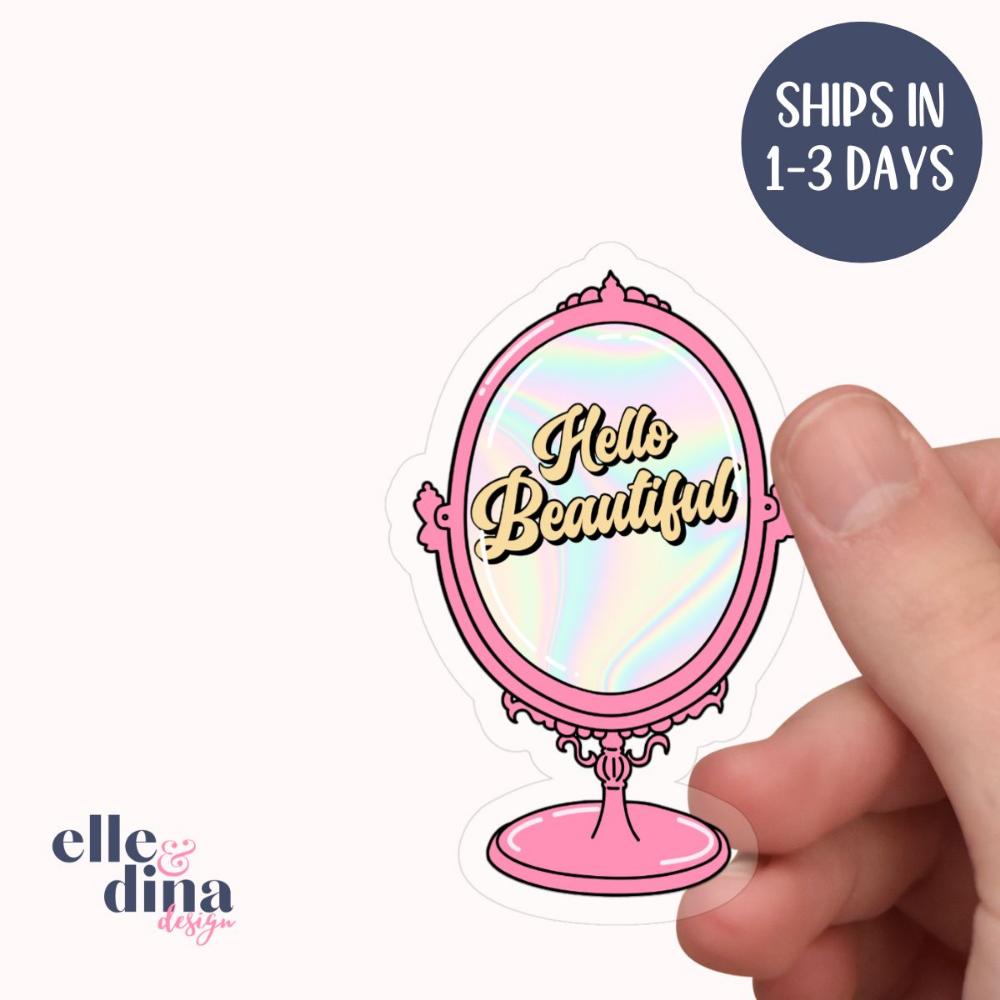 sticker of pink stand mirror with hello beautiful in yellow text on the holo effect mirror by elle and dina design